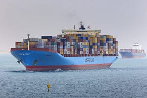 Convoy of container ships transiting the Suez Canal loom through air thick with desert sand Great B